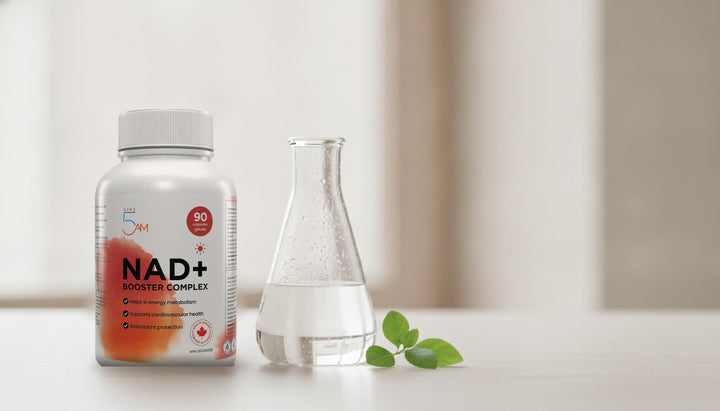 Live 5AM NAD+ Booster Complex bottle beside a glass laboratory flask on a bright counter