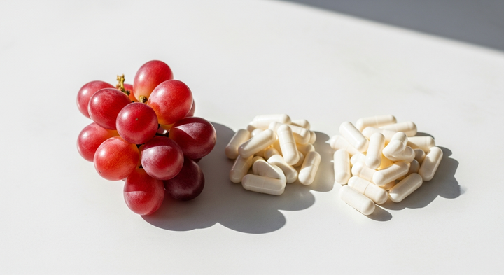 Grapes and capsules representing NMN and resveratrol