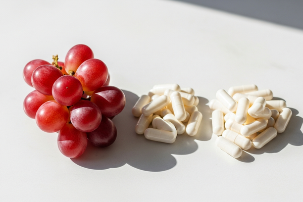 Grapes and capsules representing NMN and resveratrol